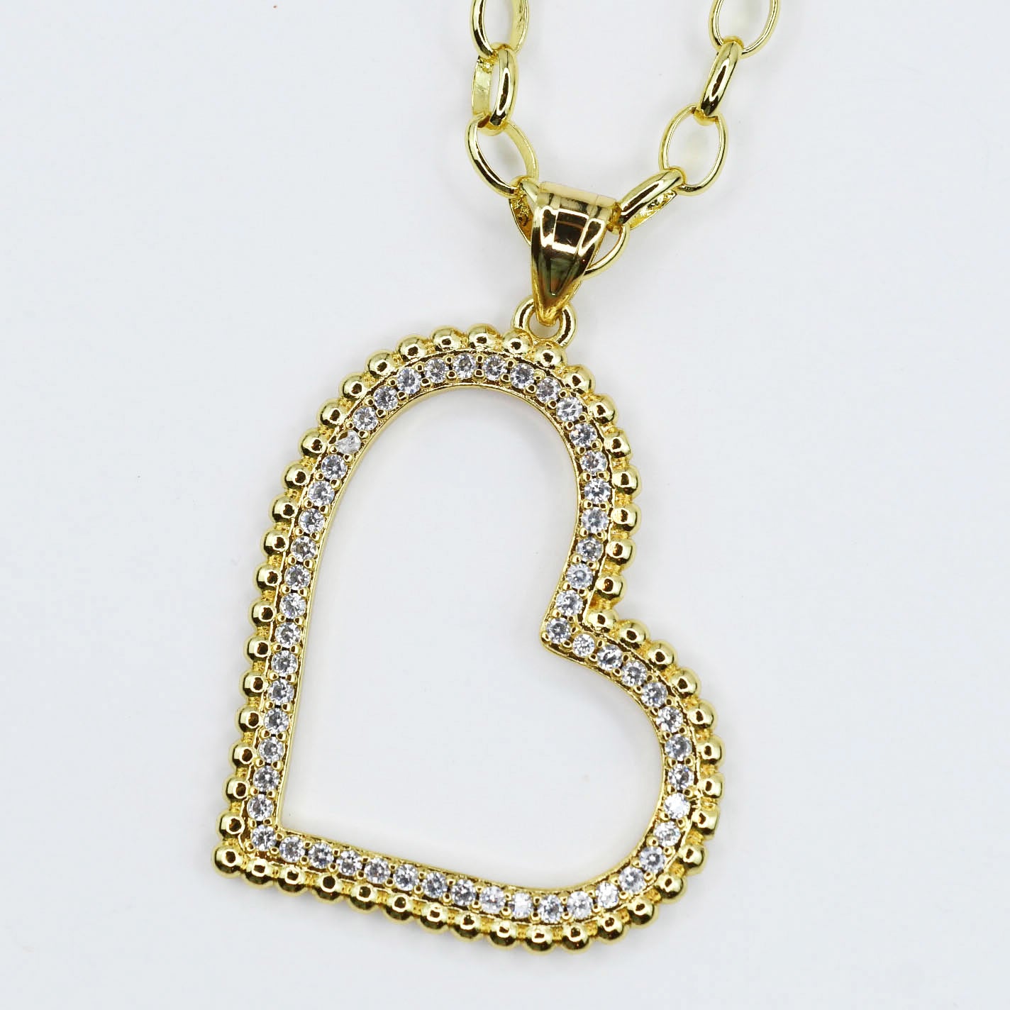 Dainty gold layered necklace, boutique wholesale jewelry, waterproof gold necklace, hypoallergenic and tarnish free statement accessory featuring a gold chain necklace with an open heart pendant adorned with small crystals