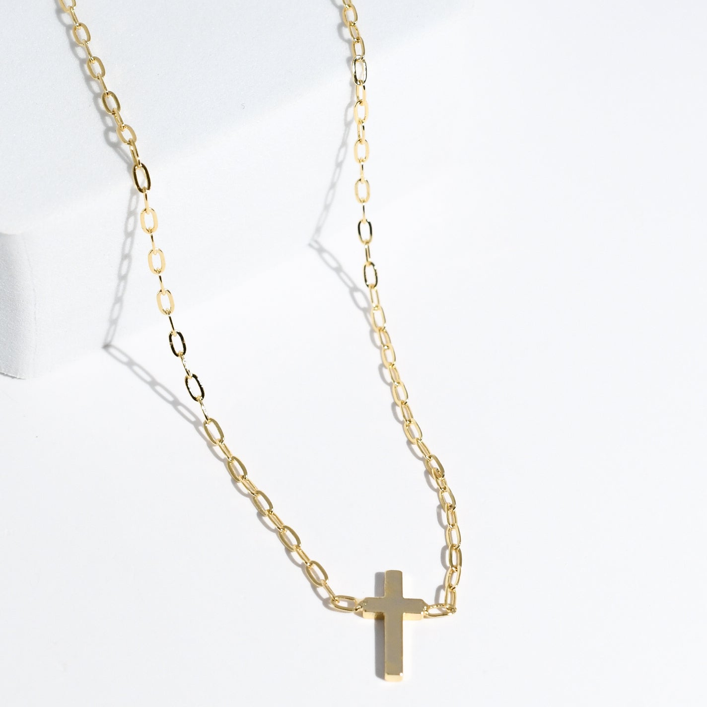 Dainty gold layered necklace with a smooth cross pendant, trendy statement accessory for wholesale jewelry for women’s boutiques and boutique wholesale jewelry, waterproof necklaces that are hypoallergenic and tarnish free