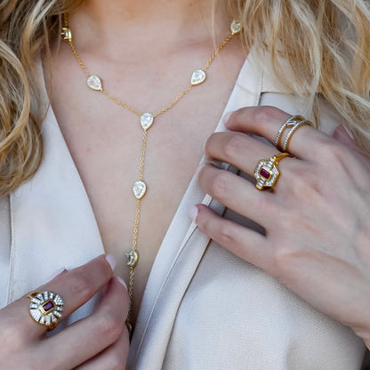 Dainty gold layered necklace, boutique wholesale jewelry, waterproof gold necklace, hypoallergenic and tarnish free statement accessory featuring a gold lariat necklace with clear teardrop pendants